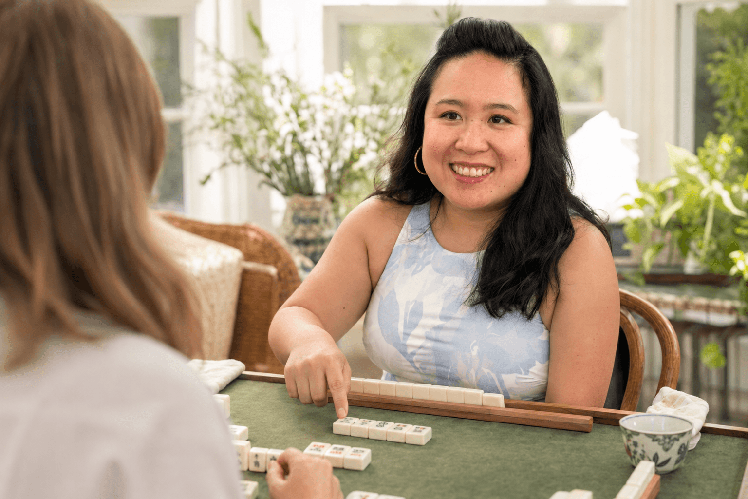 Christine demonstrating Mahjong tiles to a learner.